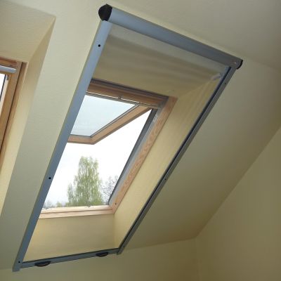 Fliegengitterrollo am Dachfenster. Dachfenster geöffnet. Draußen ein Baum