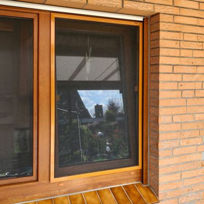 Fliegengitter-Fensterrahmen von außen. Braun. An Backsteinwand
