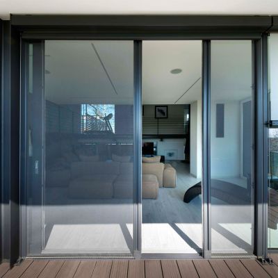 Fliegengitterrollotür von außen fotografiert frontal. Leicht geöffnet. Sehr breite Tür